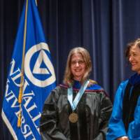 Provost Mili takes picture with woman